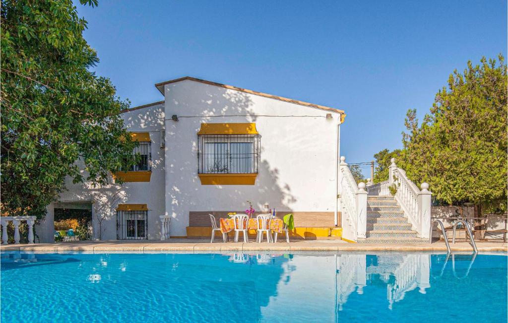 トマレスにあるNice Home In Tomares With 7 Bedrooms, Wifi And Swimming Poolの家の前にスイミングプールがある家