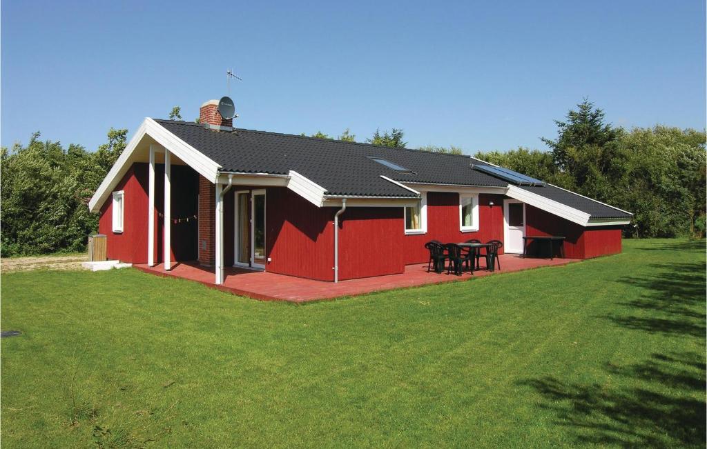 una casa roja y blanca con una mesa en el césped en 3 Bedroom Gorgeous Home In Vestervig en Vestervig