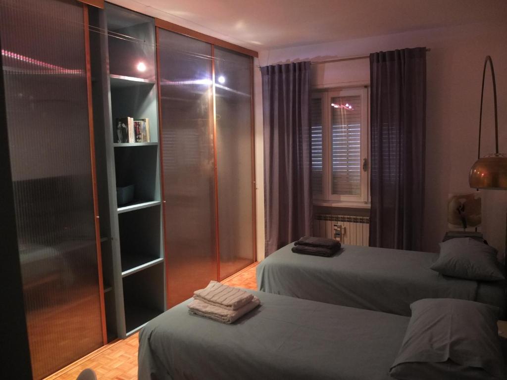 a bedroom with two beds and a walk in closet at #iRicci3stanze in Monfalcone