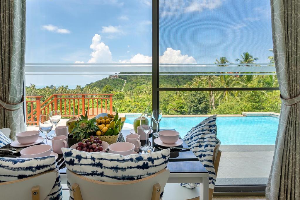 comedor con mesa y vistas a la piscina en 3BR Beautiful New Villa Mikia SDV007 with amazing Sea and Mountain Views-By Samui Dream Villas, en Mae Nam