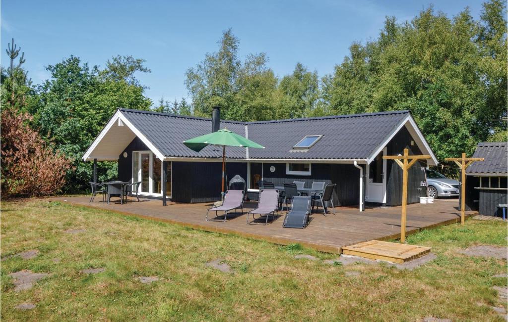 a house with a patio with chairs and an umbrella at Amazing Home In Oksbl With Wifi in Oksbøl