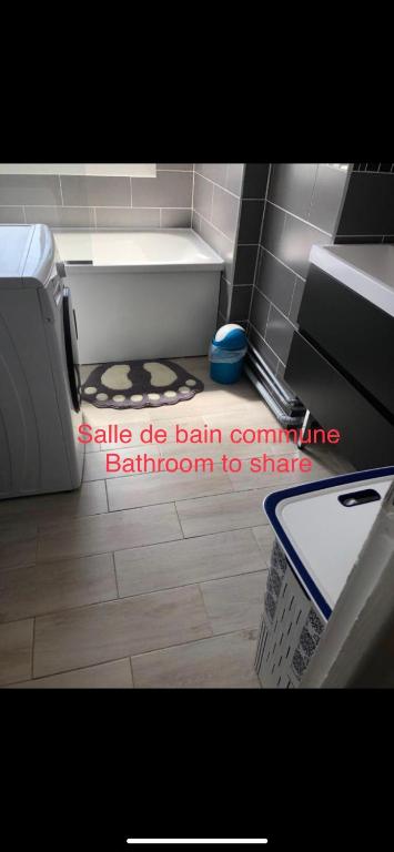 a bathroom with a sink and a floor with a basket at Chambres privées Calais Ferry-Port-Place d&#39;armes in Calais
