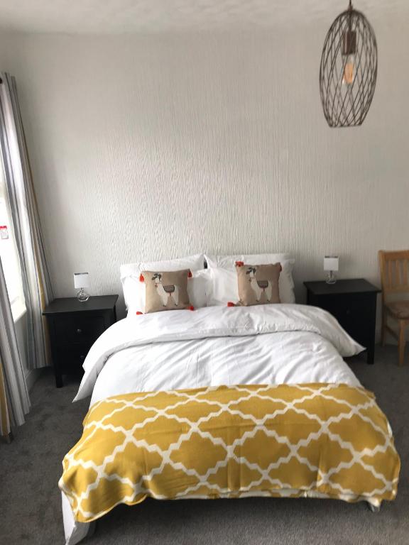 Un dormitorio con una cama con una manta amarilla. en Home on the Park en Mánchester
