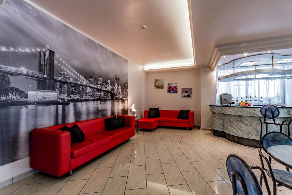 a living room with a red couch and a bar at Hotel San Paolo in Rimini