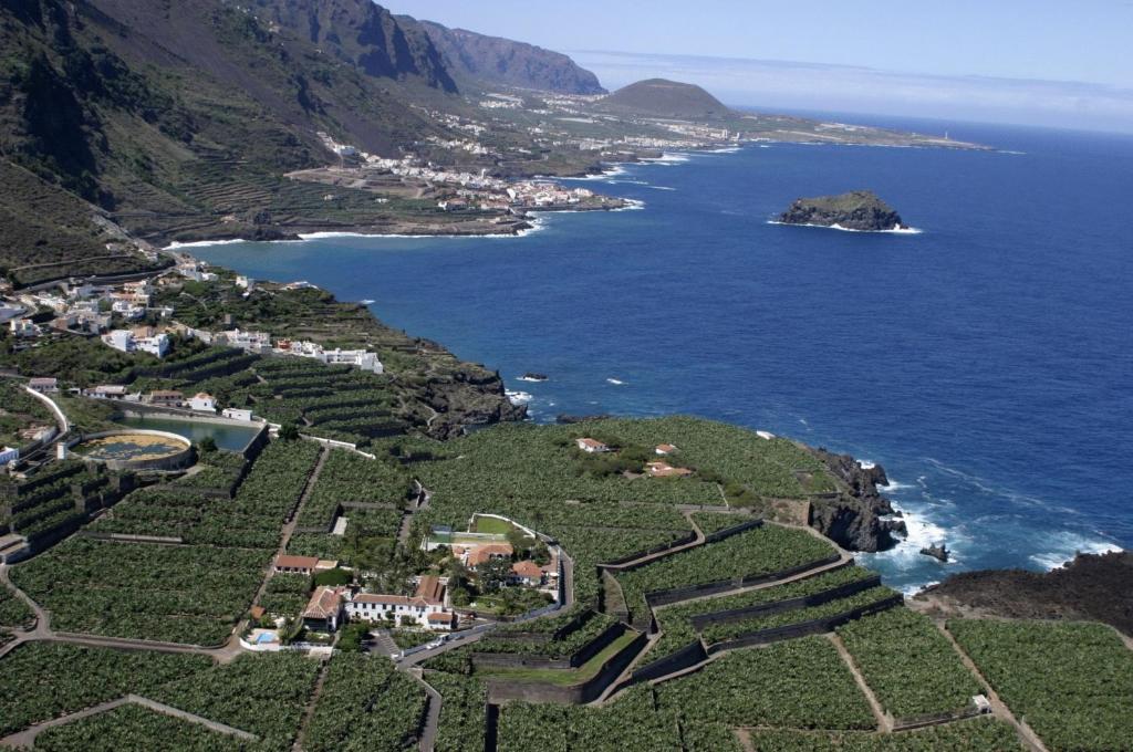 an aerial view of a village on a hill next to the ocean at Malpais Trece in Garachico