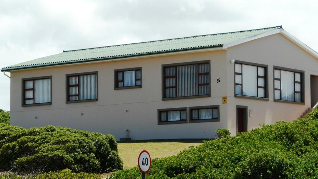 a large white house with black windows at Oyster Catcher Stay And Explore in Cape St Francis