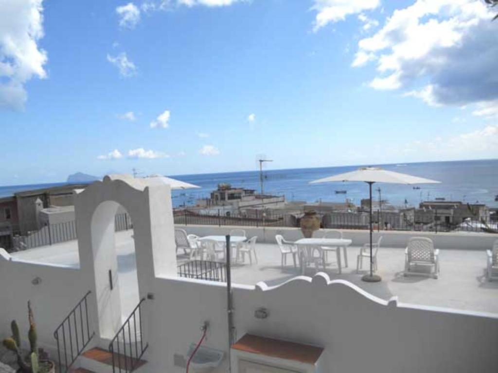 eine Terrasse mit Tischen und Sonnenschirmen und dem Meer in der Unterkunft Casa Baja in Lipari