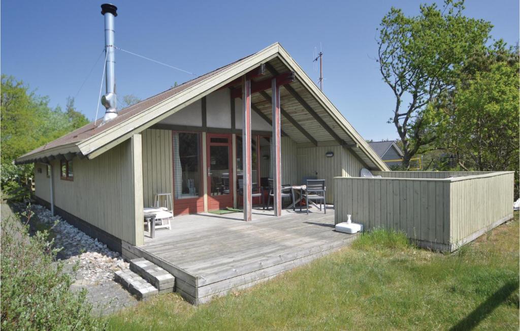 una casa con terraza de madera en el patio en 3 Bedroom Pet Friendly Home In Blvand, en Blåvand