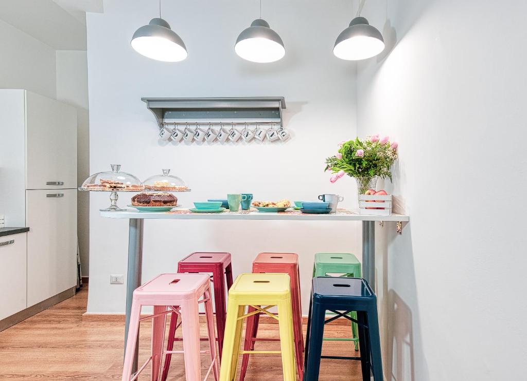 eine Reihe farbenfroher Hocker unter einer Küchentheke in der Unterkunft Relais Mantellini in Rom