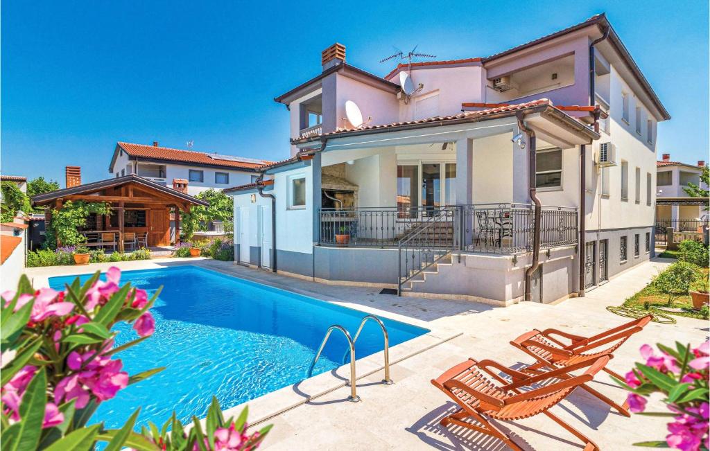 a villa with a swimming pool and a house at Beautiful Home In Valbandon With Wifi in Štinjan