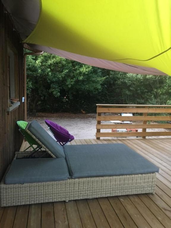 a bed on a deck under a tent at comme chez vous in Taussat-les-Bains