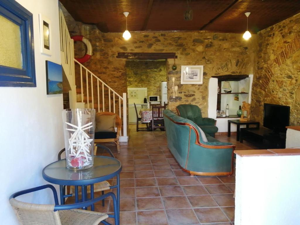 een woonkamer met een bank, stoelen en een tafel bij Casa de pescadores in Llança