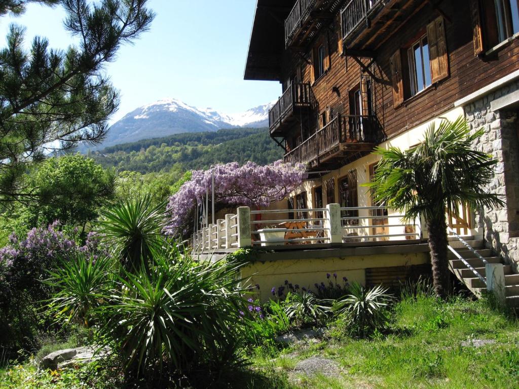 un edificio con un balcón con una montaña en el fondo en Le Vieux Chalet, en Embrun