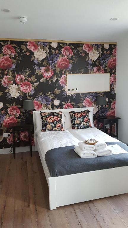 a bedroom with a bed with a floral wallpaper at Pasta Factory Guest Rooms in Galway