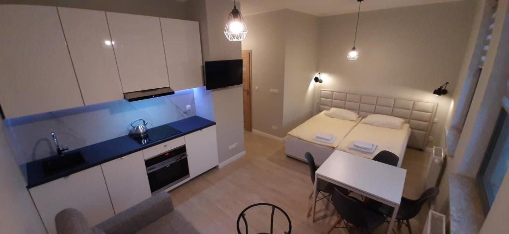 a small room with a bed and a kitchen at Garden Gates and Sadowa Apartments in Gdańsk
