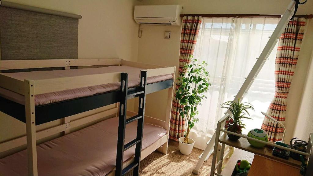 a room with two bunk beds and a window at CASA HORIZONTE in Hachioji