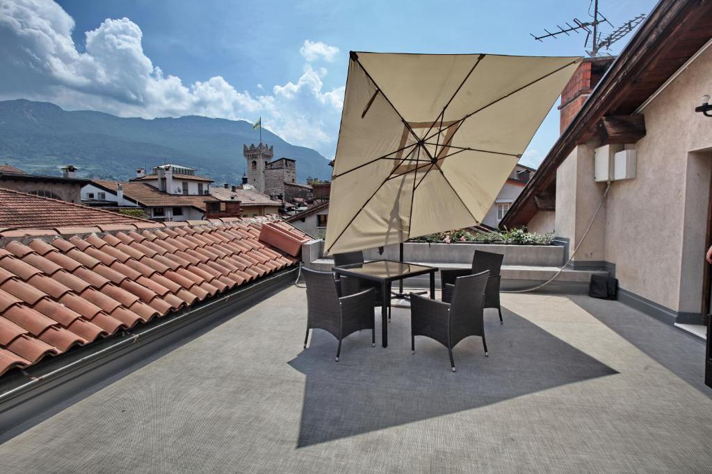 patio ze stołem, krzesłami i parasolem w obiekcie Albergo Accademia w Trydencie
