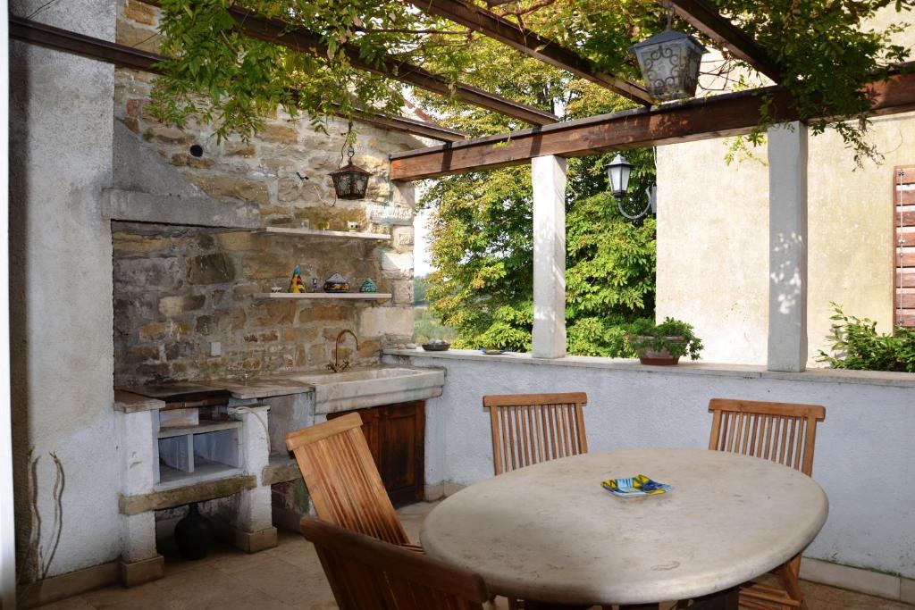 una cocina al aire libre con mesa, sillas y fregadero en Villa Antica, en Grožnjan