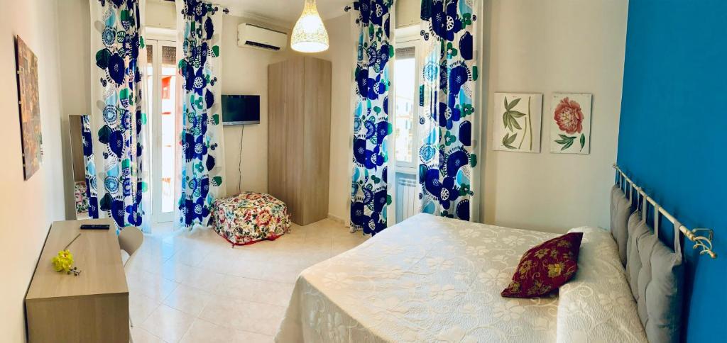 um quarto com cortinas azuis e brancas e uma cama em Mary Louise B&B em Roma