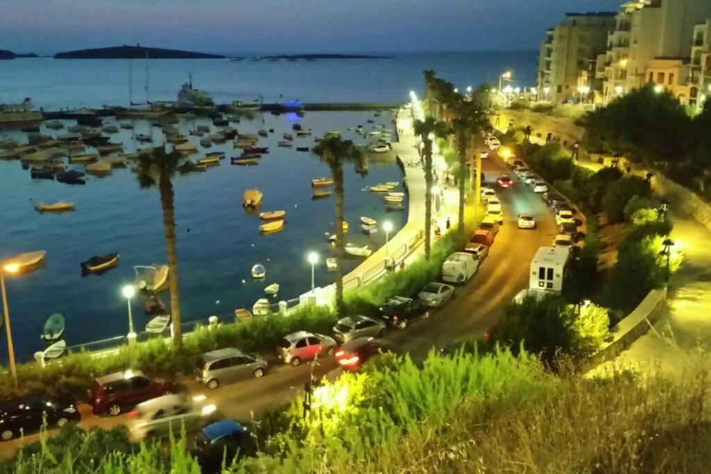 - une vue sur le port la nuit avec des bateaux dans l'eau dans l'établissement Side Sea View Porto Paolo C, à San Pawl il-Baħar