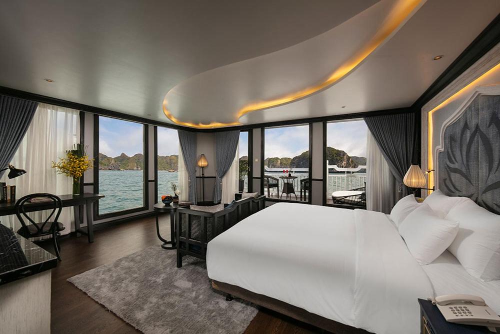 a bedroom with a large white bed with a view of the water at LaPinta Boutique Cruises in Ha Long