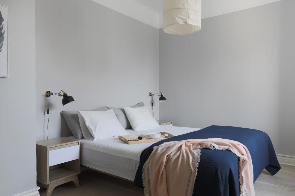 1 dormitorio con cama con almohadas blancas y mesa en Linne Apartment en Uppsala