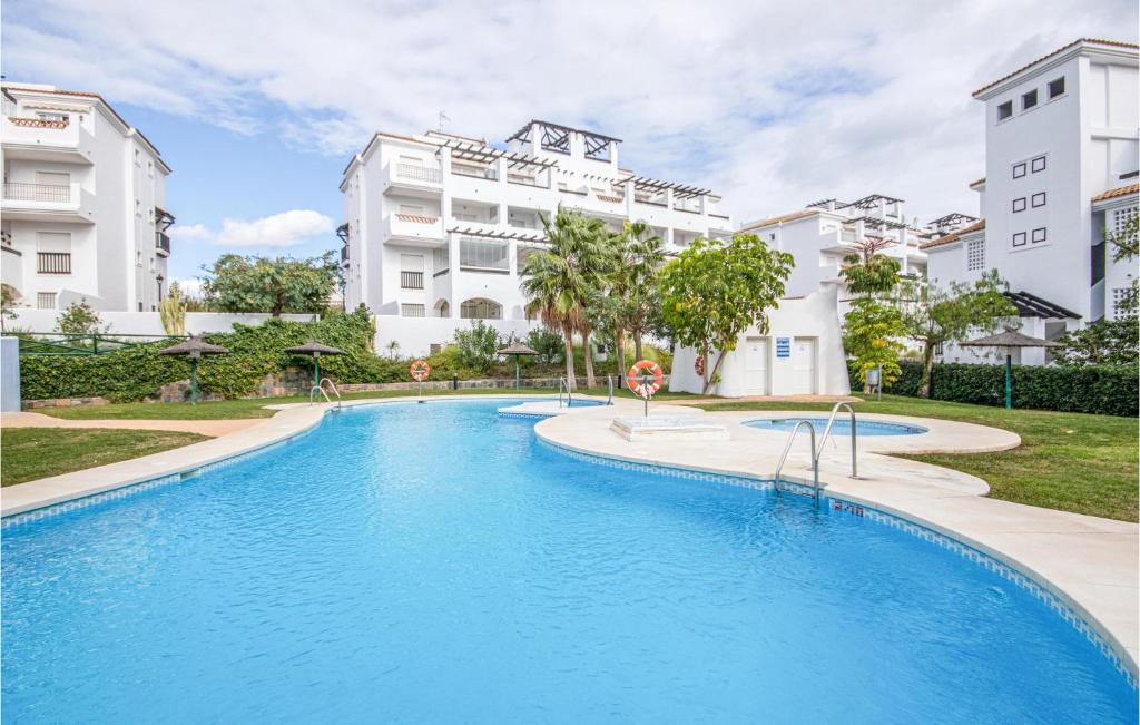 サン・ルイス・デ・サビニリャスにあるBeautiful Apartment In San Luis De Sabinillas With Swimming Poolの一部の建物の前にスイミングプールがあります。