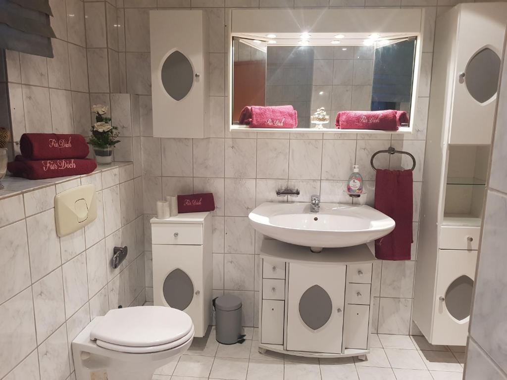 a bathroom with a toilet and a sink at Ferienwohnung Parkblick Medebach in Medebach