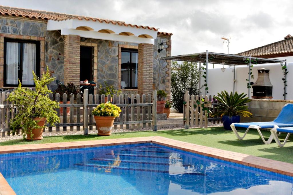 Villa con piscina frente a una casa en Chalet Mirlo, en Conil de la Frontera