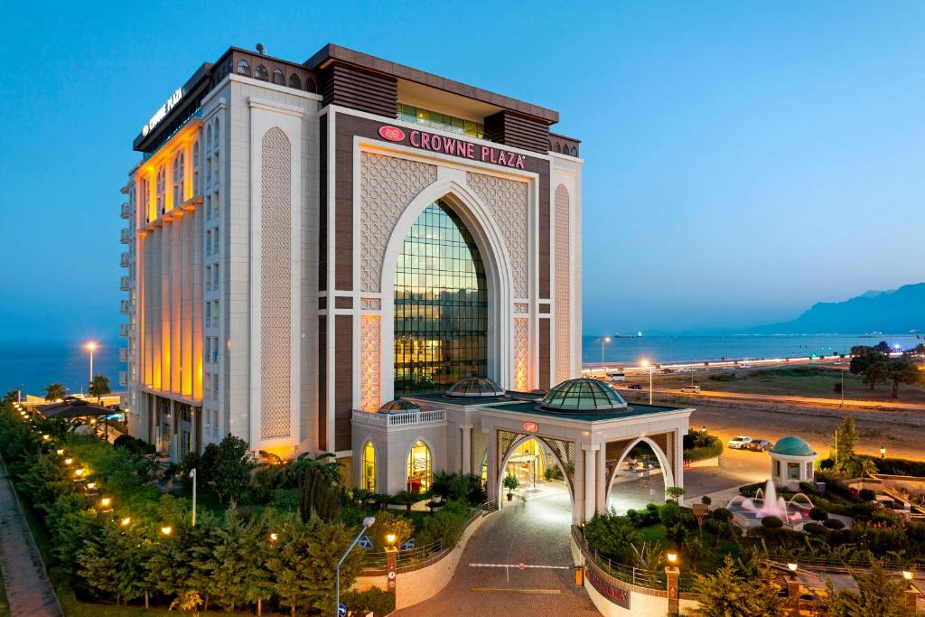 a hotel with a large building at night at Crowne Plaza Antalya by IHG in Antalya