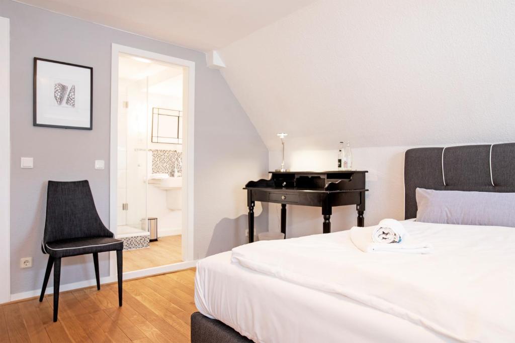 ein Schlafzimmer mit einem Klavier und einem Bett mit einem Stuhl in der Unterkunft Hotel Essgold in Ratingen