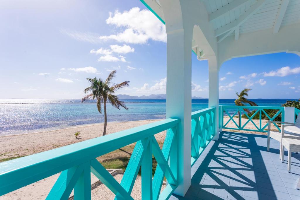 una casa en la playa con vistas al océano en Coralito Bay Suites & Villas en The Valley