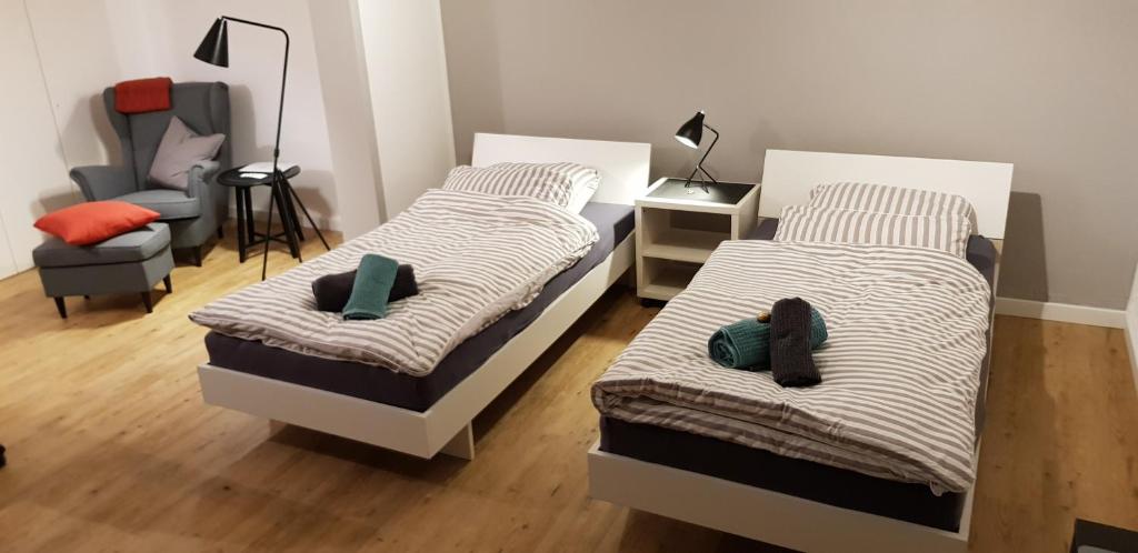 1 dormitorio con 2 camas y 1 silla en Apartment Messe Köln en Rösrath