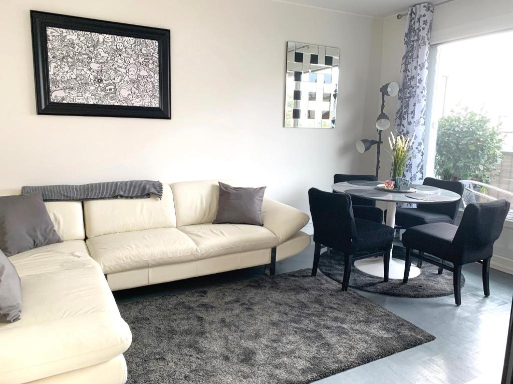 a living room with a white couch and a table at Nice flat near Paris MCP in Joinville-le-Pont