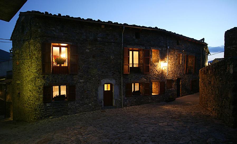 ein altes Steingebäude mit Lichtern in den Fenstern in der Unterkunft Can Janpere I in Pardines