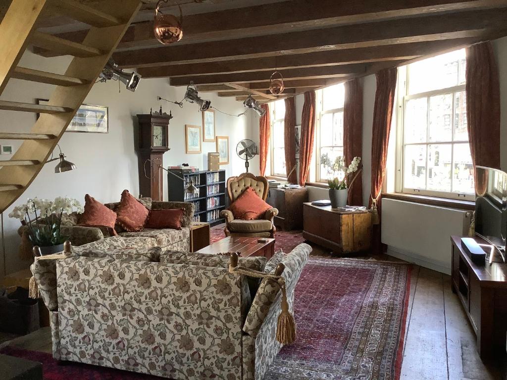 ein Wohnzimmer mit einem Sofa und einem Tisch in der Unterkunft Former Rembrandt workshop two bedroom B&B in Amsterdam