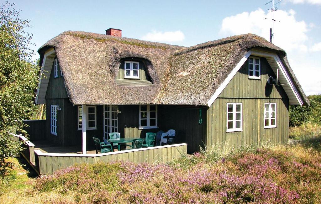 a house with a thatched roof with a patio at Holiday Home Thadesvej Rømø Iv in Toftum