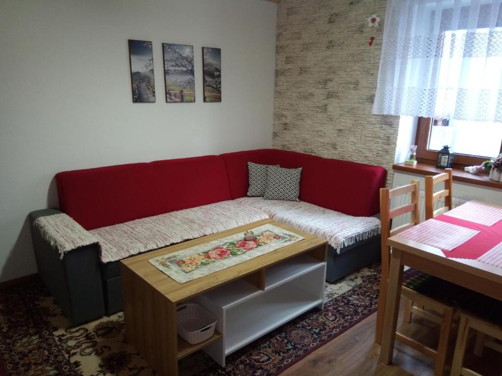 uma sala de estar com um sofá vermelho e uma mesa em Drevenica MAK Oliver em Kvačany