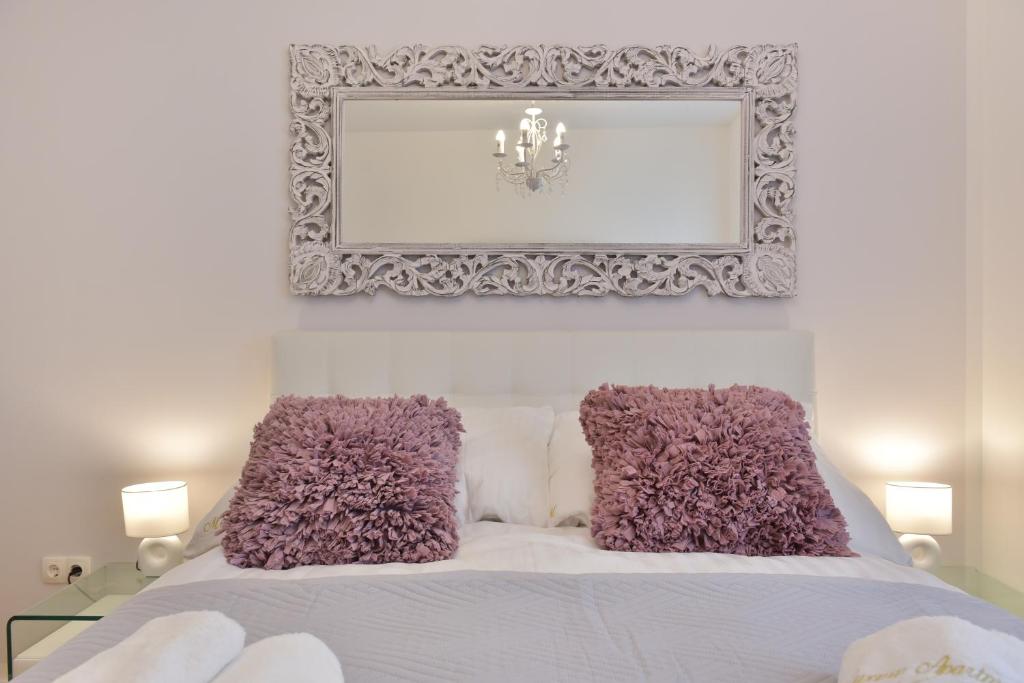 1 dormitorio con cama blanca y almohadas moradas en MM Luxury Apartments GOLD & RUBIN, en Zadar