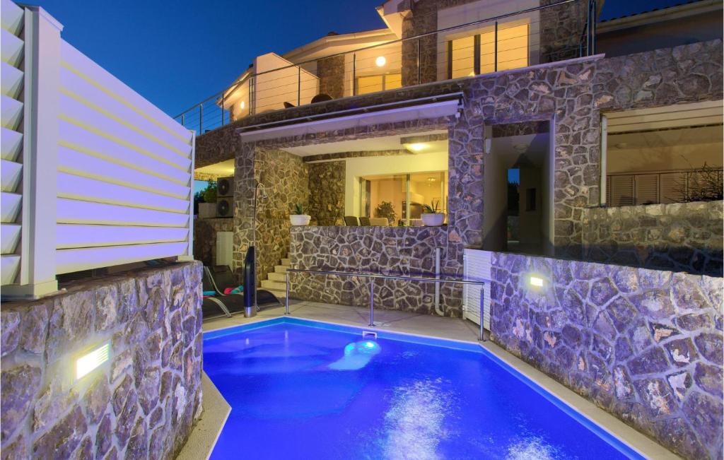 a swimming pool in front of a house at 2 Bedroom Gorgeous Home In Krk in Krk