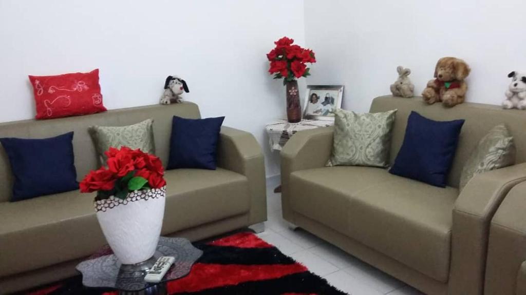 a living room with two couches and red and blue pillows at Chez Eva Jolie in Dakar