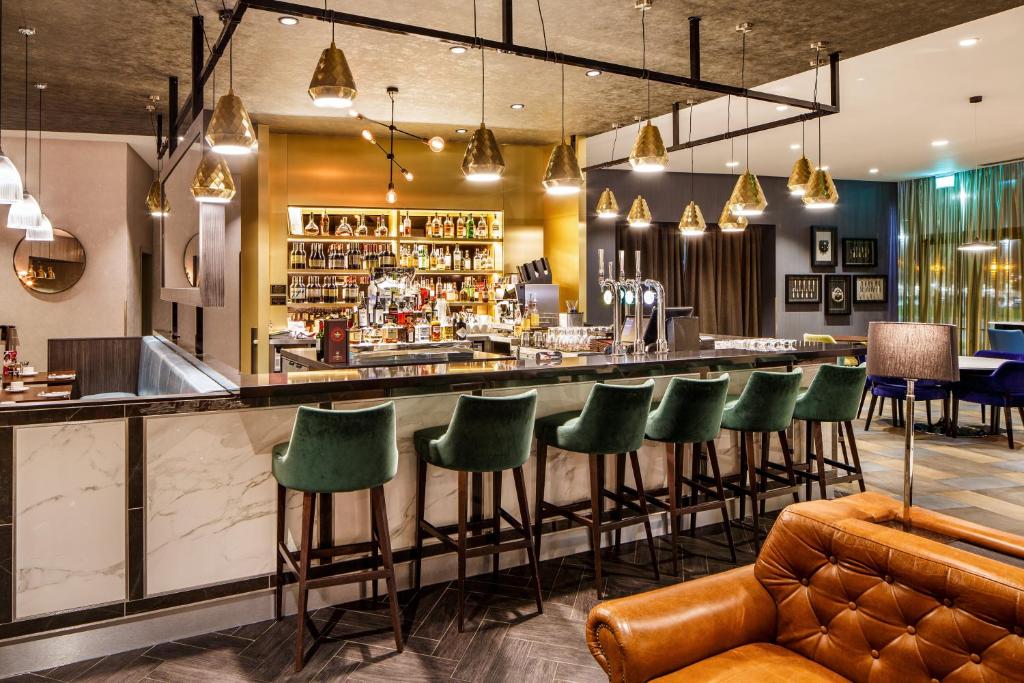 a bar with green chairs at a restaurant at Crowne Plaza Aberdeen Airport by IHG in Dyce