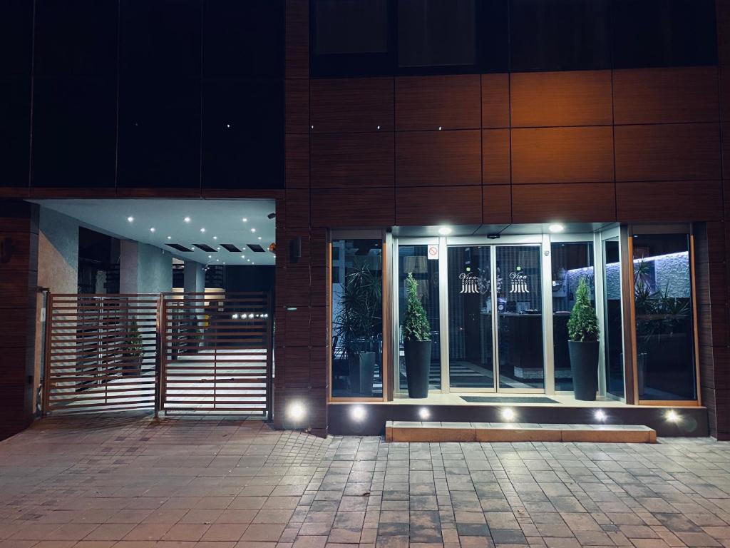 un edificio con macetas delante de él por la noche en Hotel Viva en Kragujevac