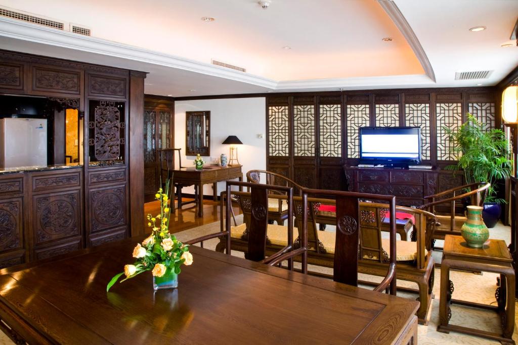 a living room with a table and chairs and a television at Crowne Plaza Qingdao, an IHG Hotel in Qingdao
