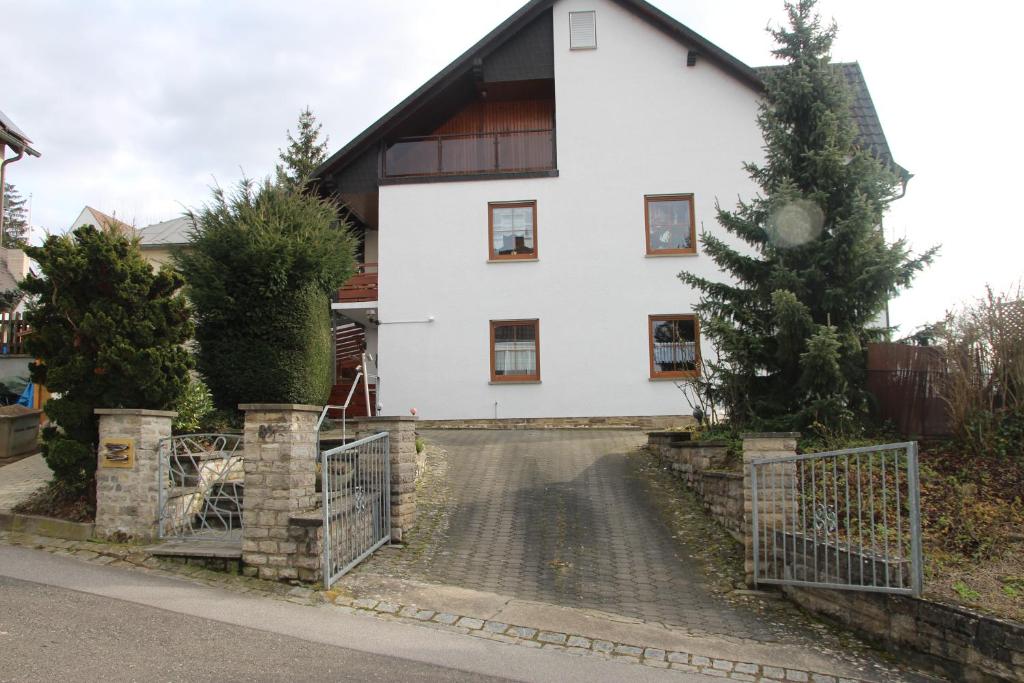 une maison blanche avec une porte en face dans l'établissement Ferienwohnung Friedrich, à Schonungen