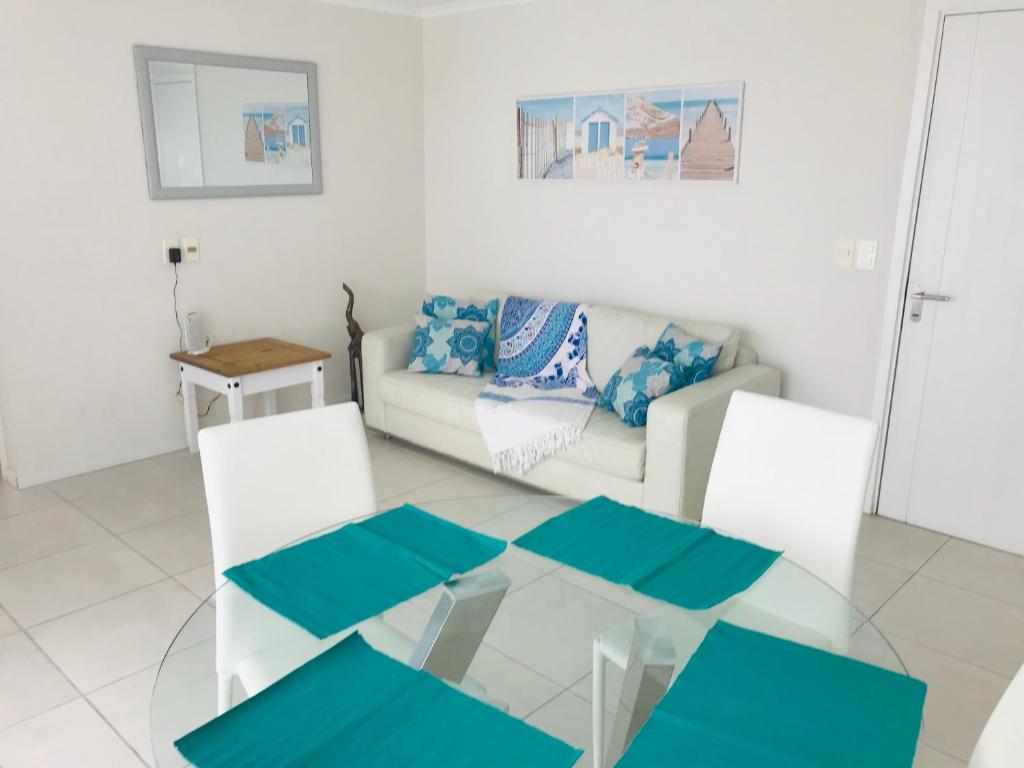 ein Wohnzimmer mit einem Glastisch und einem Sofa in der Unterkunft Cómodo apartamento en Torre Ocean Drive con todos los servicios in Punta del Este