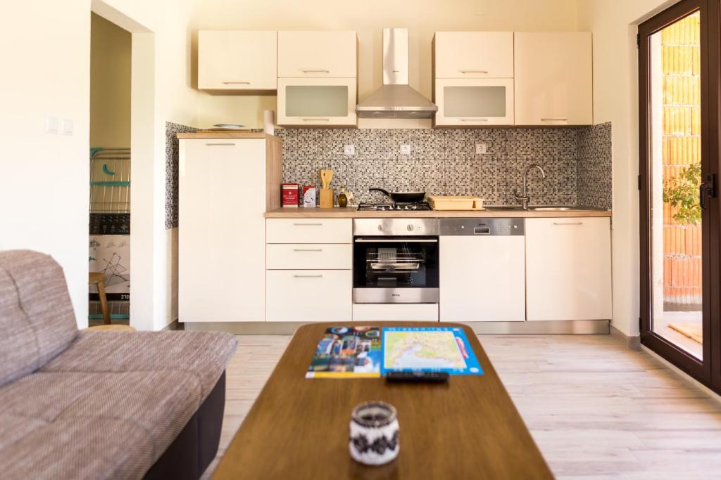 una cucina con mobili bianchi e tavolo di Villa Lovric a Marina