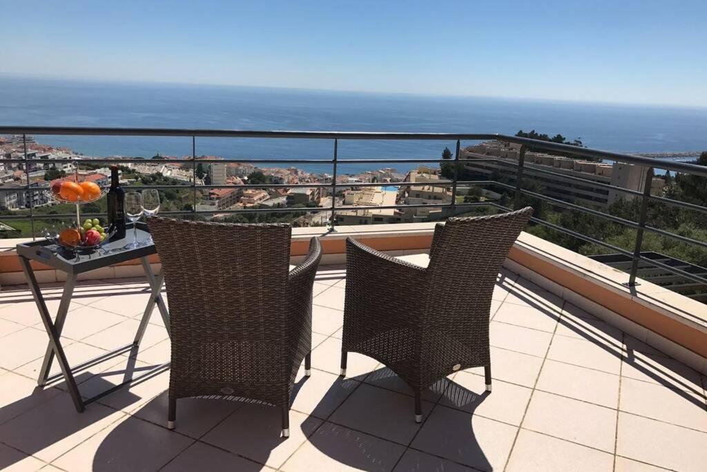 balcone con 2 sedie, tavolo e oceano di Luxus Ferienhaus Casa Paraiso a Sesimbra