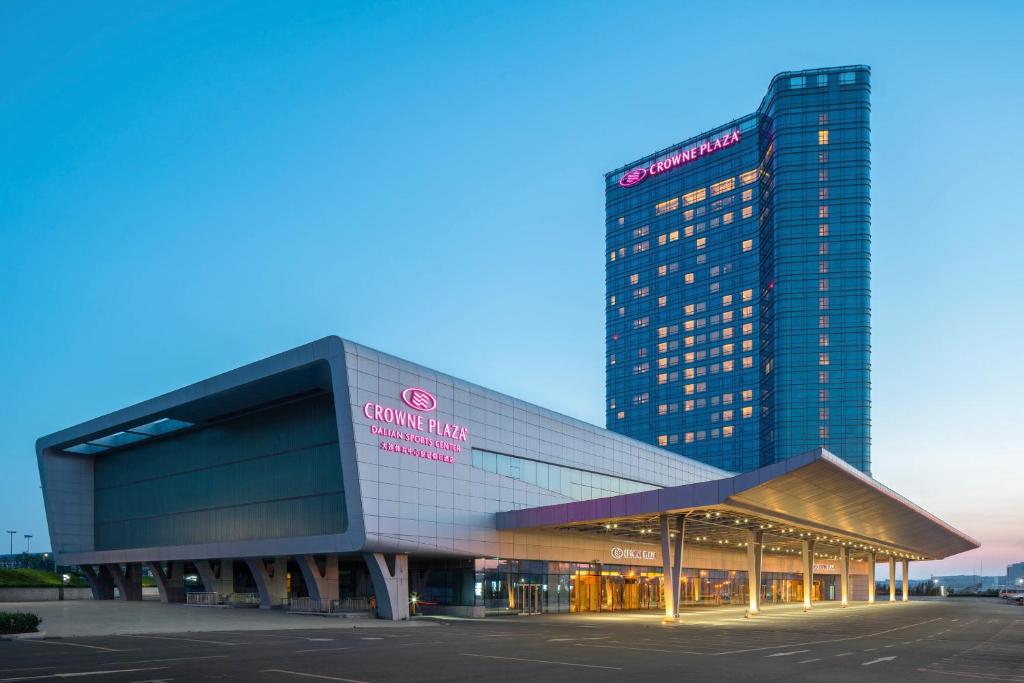 a large building with a sign on the side of it at Crowne Plaza Dalian Sports Center, an IHG Hotel in Dalian