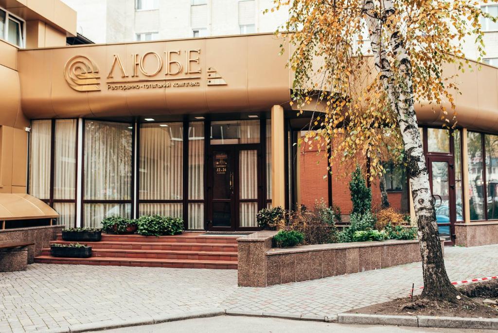 a building with a tree in front of it at Lyube in Khmelnytskyi